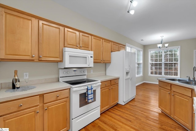 kitchen featuring a chandelier, sink, light hardwood / wood-style floors, decorative light fixtures, and white appliances