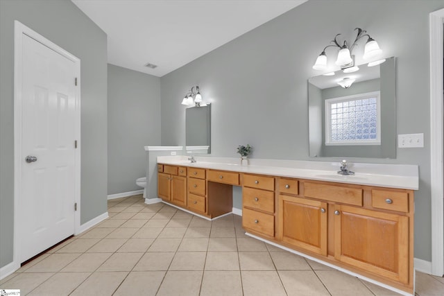 bathroom with toilet, a notable chandelier, vanity, and tile patterned floors