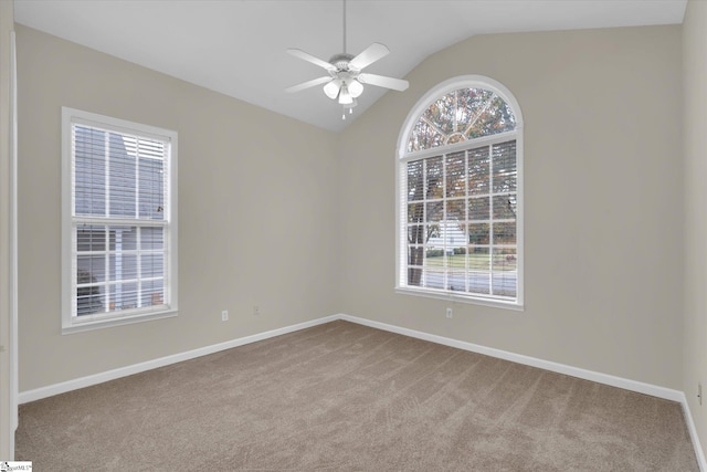 empty room with lofted ceiling, light colored carpet, and ceiling fan