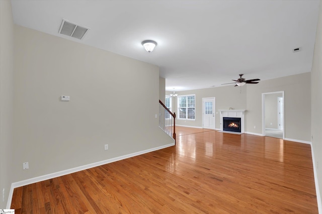 unfurnished living room with light hardwood / wood-style floors and ceiling fan with notable chandelier