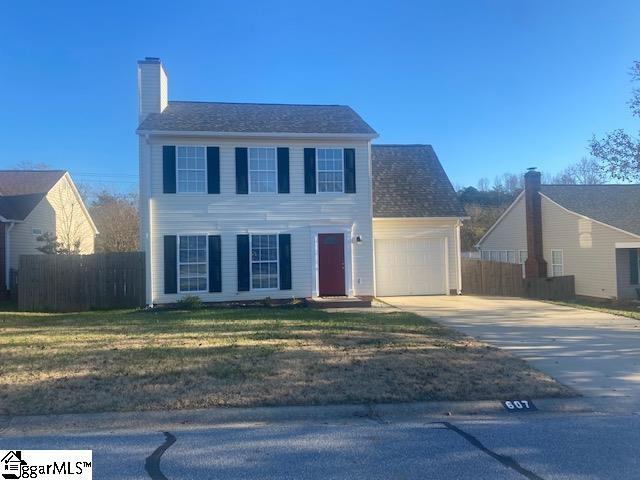 colonial home with a garage and a front lawn