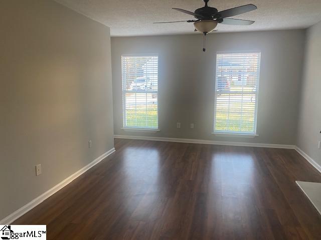 unfurnished room featuring plenty of natural light and dark hardwood / wood-style flooring