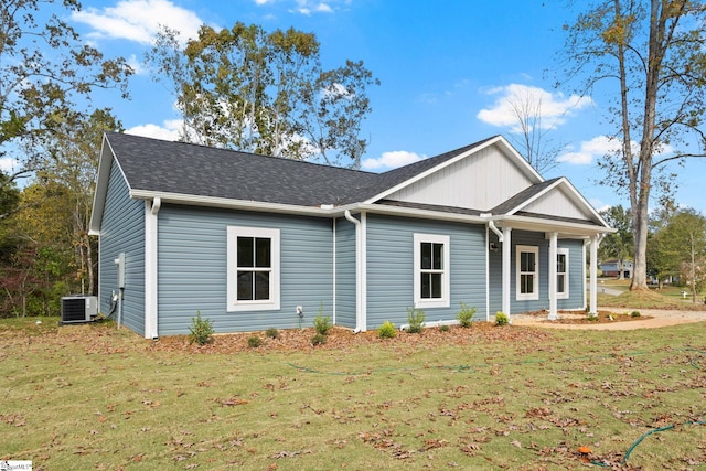 view of front of home with central AC and a front lawn