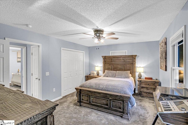 carpeted bedroom with a closet, ceiling fan, and a textured ceiling