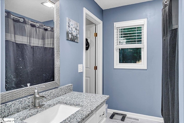 bathroom with vanity, a textured ceiling, and walk in shower