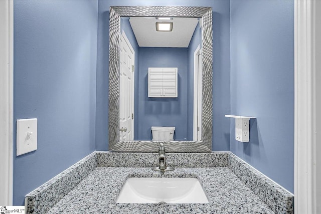 bathroom with toilet, a textured ceiling, and sink