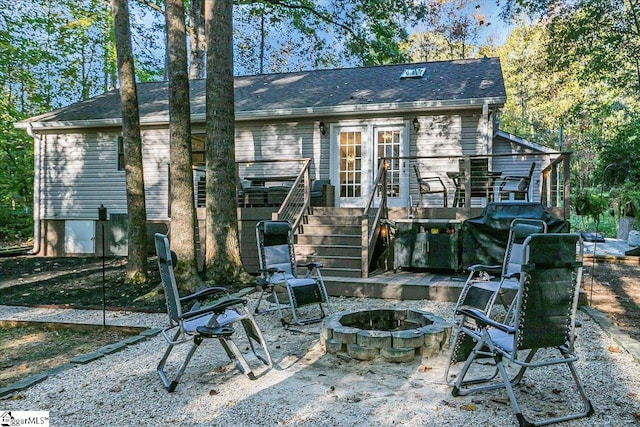 rear view of property featuring an outdoor fire pit and a deck