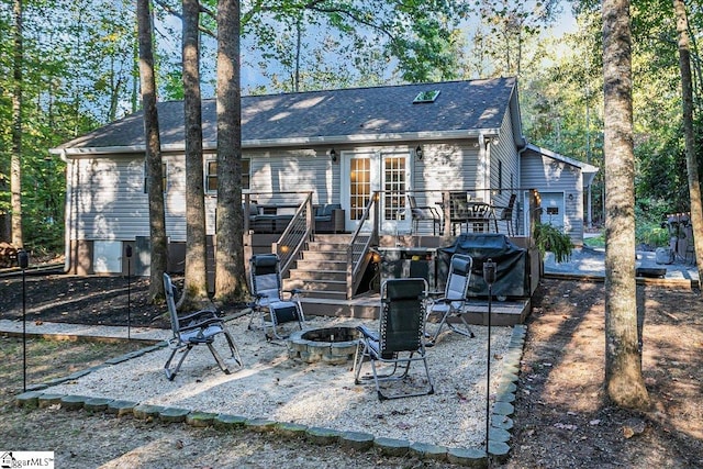 back of property featuring a deck and a fire pit