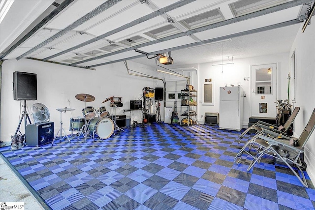 garage featuring a garage door opener and white fridge