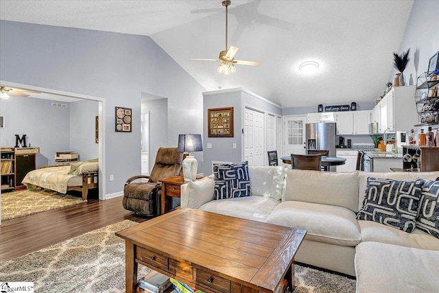 living room featuring ceiling fan, hardwood / wood-style flooring, and high vaulted ceiling