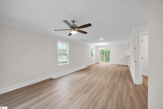 empty room with light hardwood / wood-style flooring, crown molding, a wealth of natural light, and ceiling fan with notable chandelier