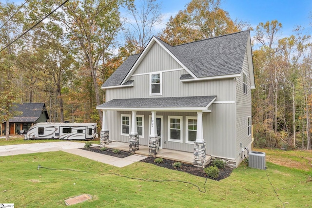 view of front of property featuring a porch, a front yard, and central air condition unit