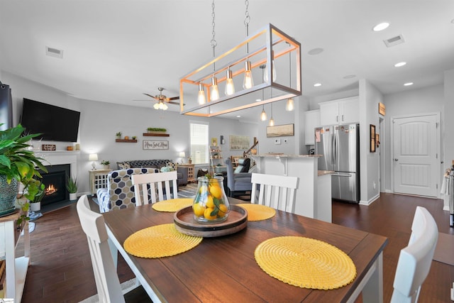 dining room with ceiling fan and dark hardwood / wood-style flooring