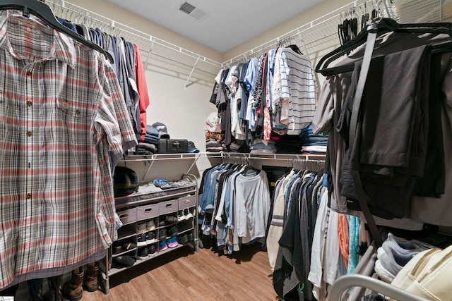 walk in closet with light hardwood / wood-style flooring