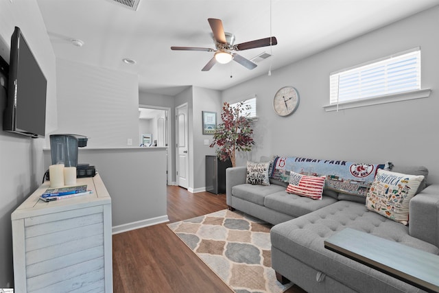 living room featuring dark wood-type flooring and ceiling fan