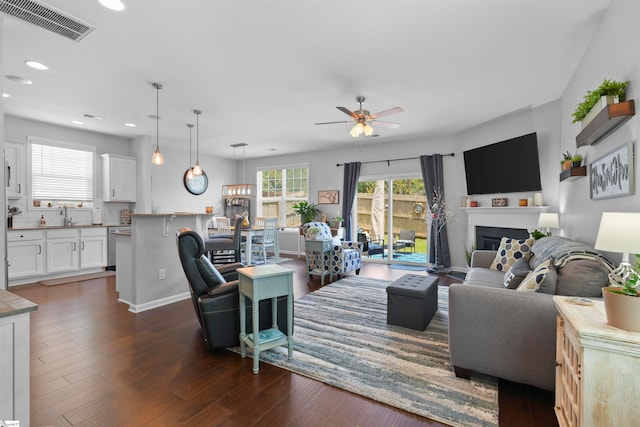 living room with ceiling fan and dark hardwood / wood-style flooring