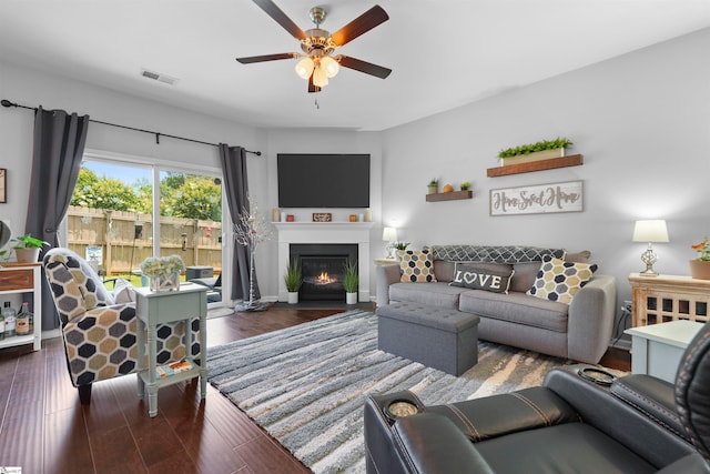 living room with dark wood-type flooring and ceiling fan