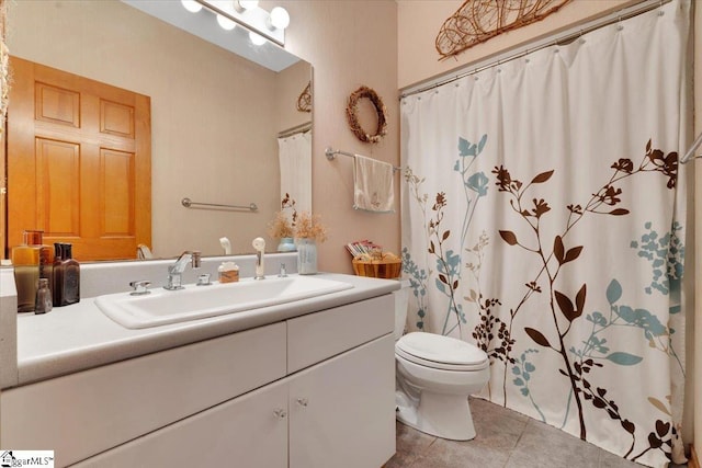 bathroom with tile patterned flooring, vanity, and toilet