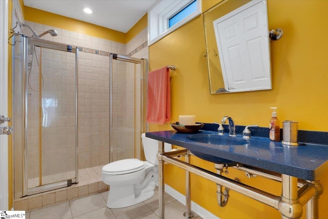 bathroom with a shower with door, tile patterned flooring, toilet, and sink