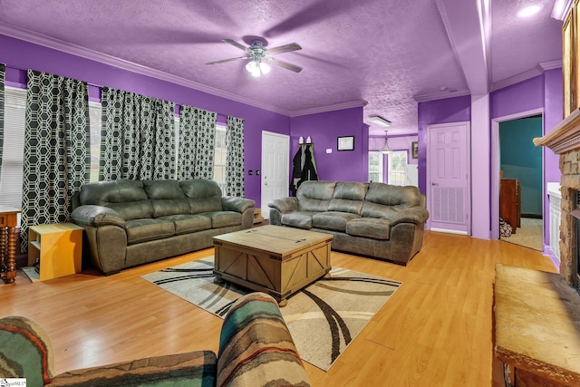 living room featuring a textured ceiling, crown molding, and wood-type flooring