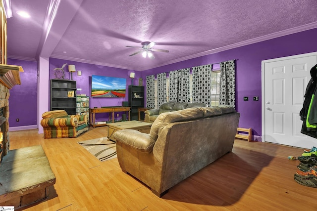 living room with ornamental molding, light hardwood / wood-style flooring, a textured ceiling, and ceiling fan