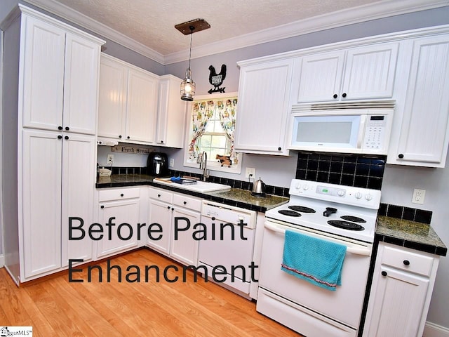 kitchen featuring crown molding, pendant lighting, sink, white cabinets, and white appliances