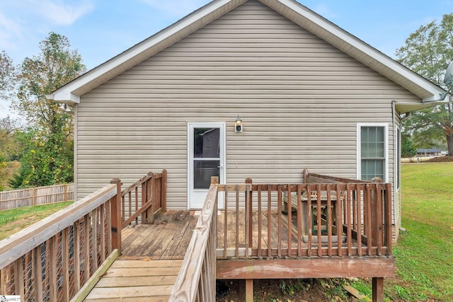 back of house with a wooden deck and a lawn