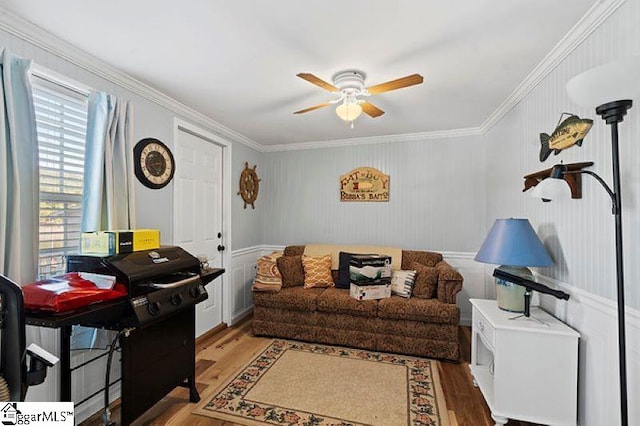 living room with hardwood / wood-style floors, ceiling fan, and crown molding