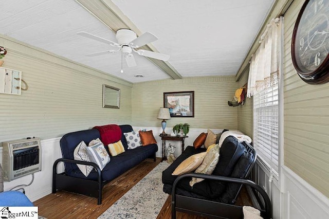 living room with dark wood-type flooring, heating unit, wooden walls, and ceiling fan