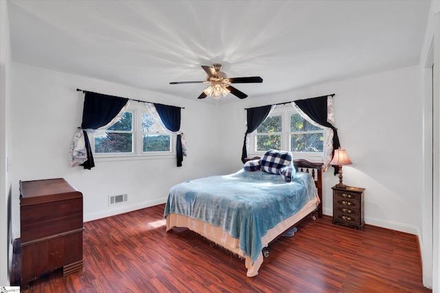 bedroom with dark hardwood / wood-style flooring, multiple windows, and ceiling fan