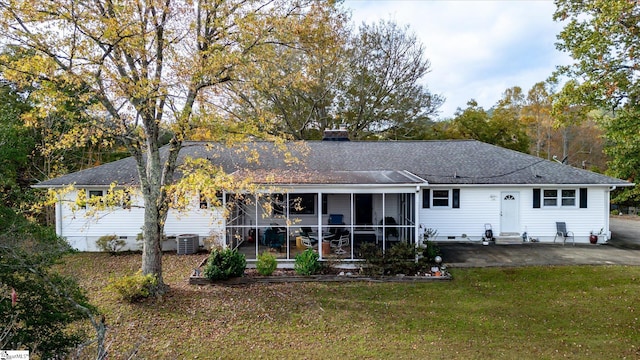 back of house with central AC, a lawn, a patio, and a sunroom