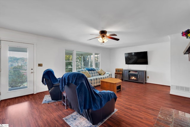 living room featuring ornamental molding, a fireplace, dark hardwood / wood-style flooring, and ceiling fan