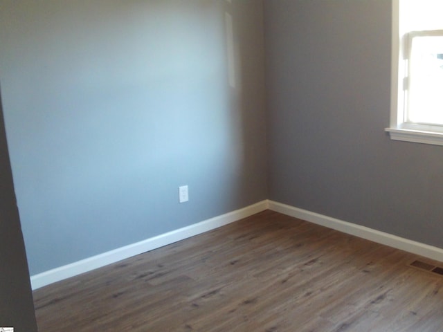 empty room featuring dark wood-type flooring