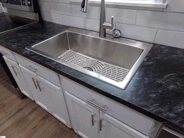 details with white cabinets, dark hardwood / wood-style floors, sink, and decorative backsplash