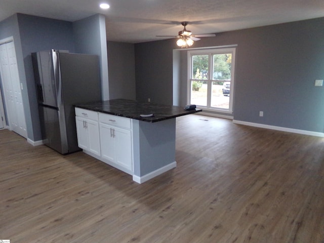 kitchen with hardwood / wood-style flooring, white cabinetry, stainless steel refrigerator, and ceiling fan