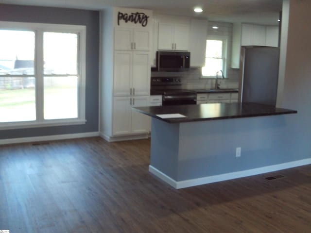 kitchen with black appliances, white cabinetry, sink, and dark hardwood / wood-style floors