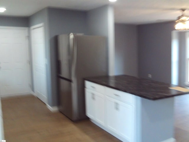 kitchen with white cabinetry, stainless steel fridge, and light hardwood / wood-style flooring