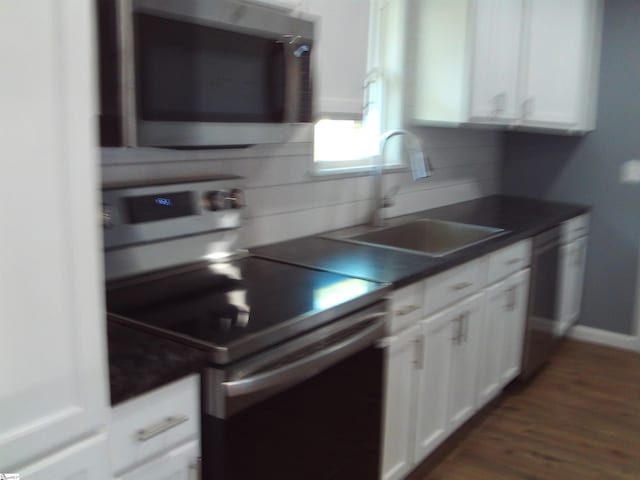 kitchen featuring white cabinetry, sink, backsplash, white appliances, and dark hardwood / wood-style flooring