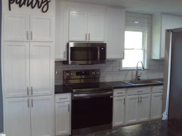 kitchen featuring white cabinetry, stainless steel appliances, sink, and backsplash