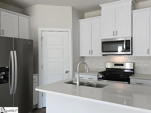 kitchen featuring decorative backsplash, white cabinetry, sink, and stainless steel appliances