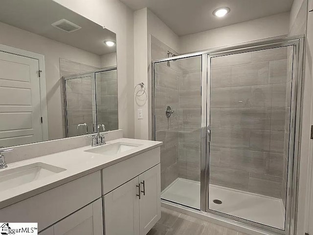 bathroom featuring walk in shower and vanity