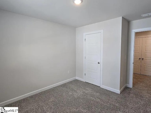 unfurnished bedroom with a closet and dark carpet