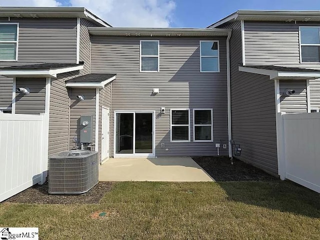 back of property with central AC unit, a yard, and a patio