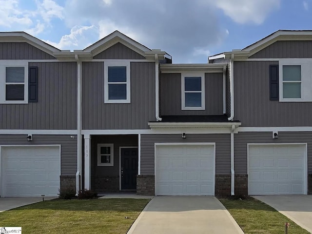 view of property featuring a garage and a front yard