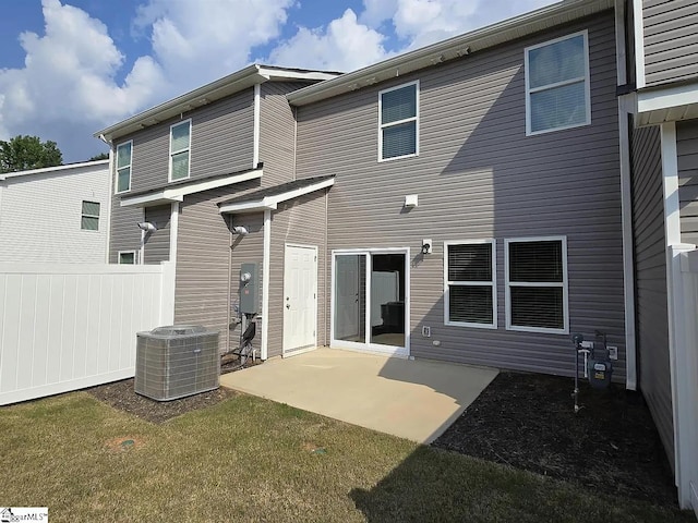 rear view of property with a lawn, central AC, and a patio area