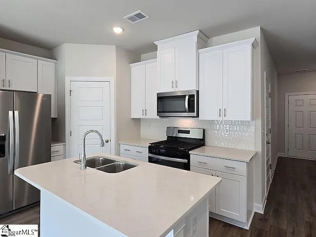 kitchen featuring white cabinetry, sink, an island with sink, and stainless steel appliances