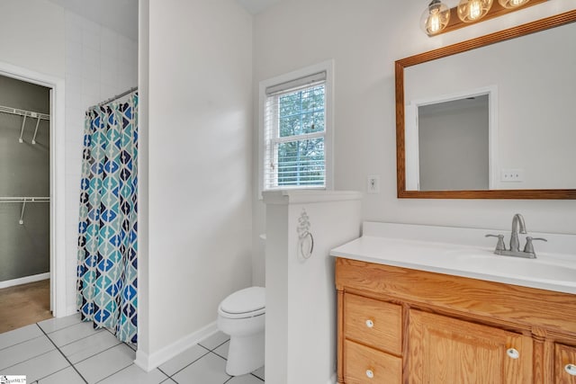 bathroom with toilet, vanity, and tile patterned floors