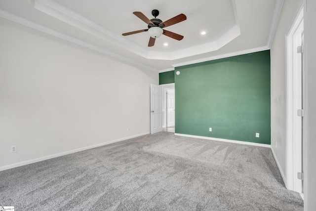 carpeted spare room with a tray ceiling, ceiling fan, and crown molding