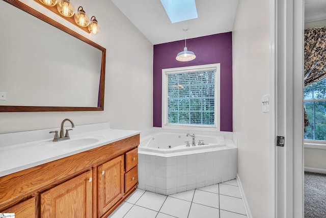 bathroom featuring vanity, plenty of natural light, a relaxing tiled tub, and a skylight