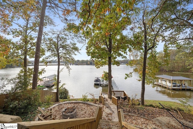 property view of water featuring a fire pit and a boat dock